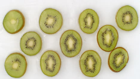 In-slow-motion-water-splashes-pour-water-onto-a-beautiful-juicy-citrus-fruit-a-lot-of-kiwi-on-a-white-background